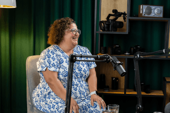 Leasing-Teamleiterin Sevda Willmann sitzt in einem Podcaststudio. Vor ihr ist ein Mikrofon aufgebaut.