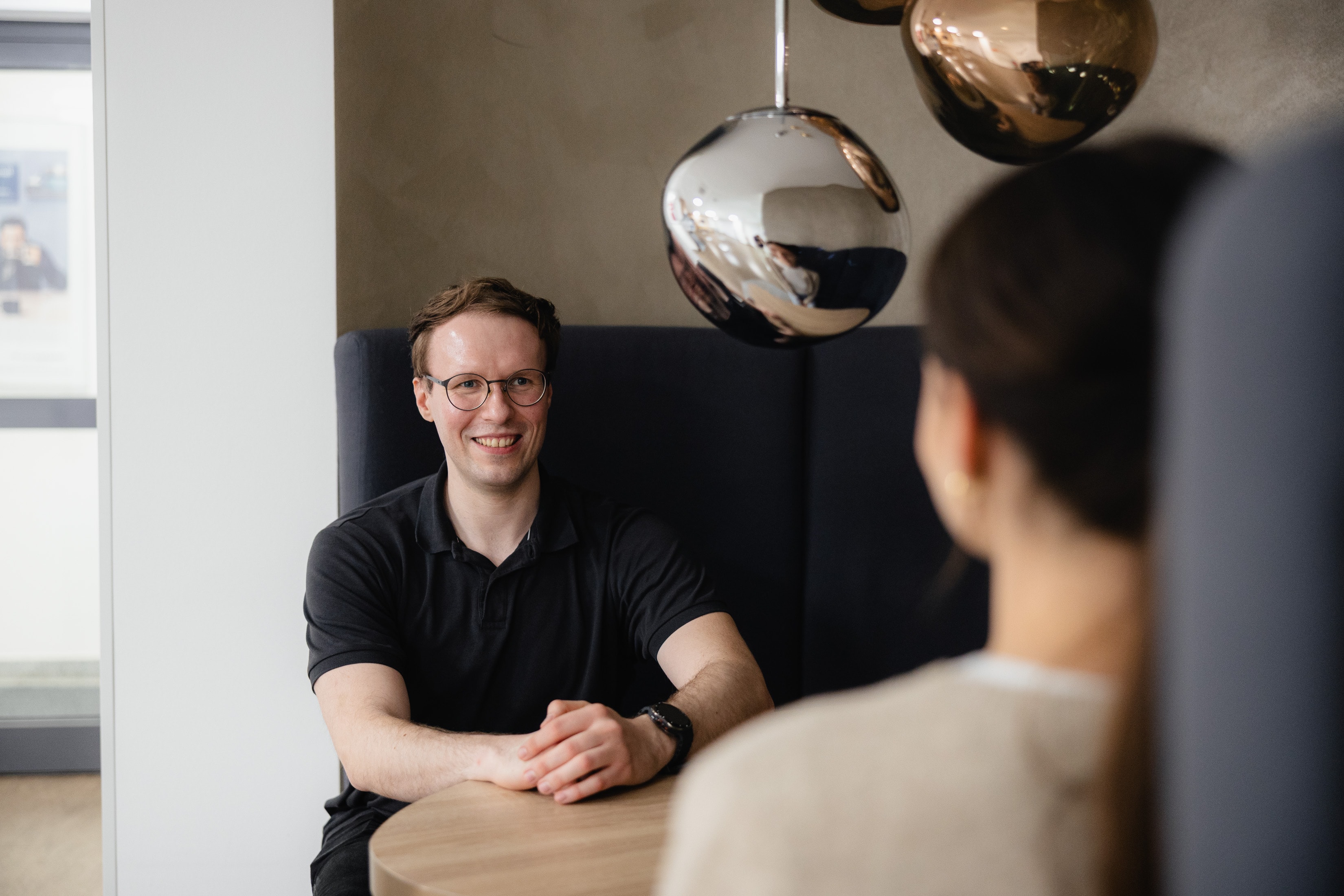 Der Karriereweg nach der Übernahme Interviewsituation am Tisch zwischen Technical Analyst Edwin Tkatzyk und Content-Managerin Mira Langner der WERTGARANTIE Group.