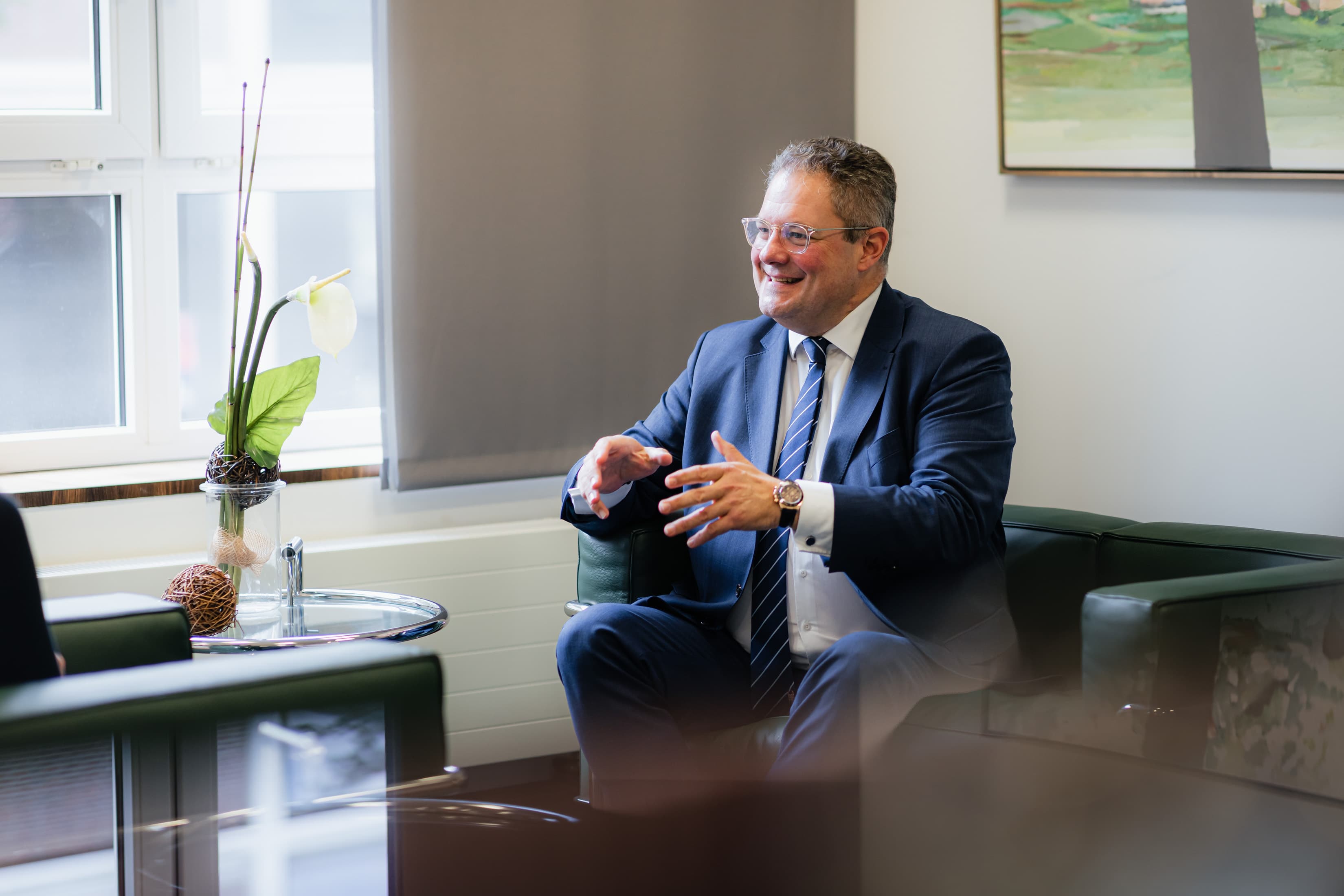 Patrick Döring im Interview Patrick Döring, Vorstandsvorsitzender der WERTGARANTIE Group, sitzt auf einem Sessel in einer Interviewsituation